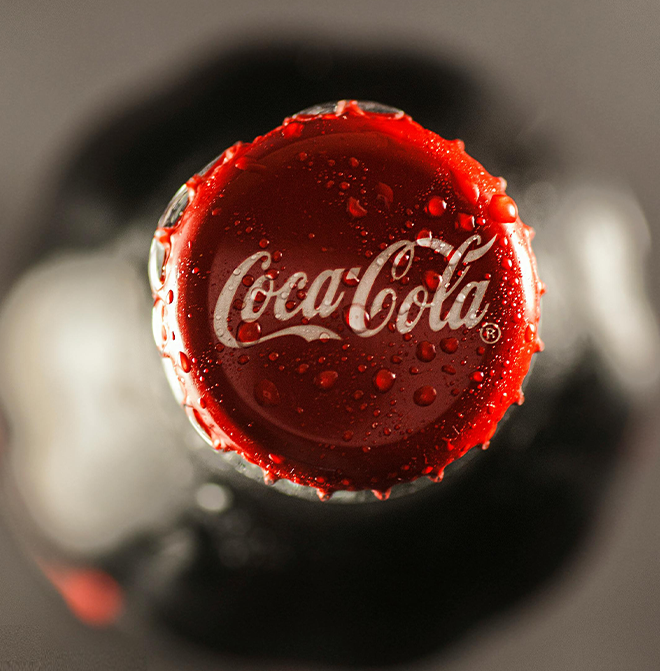 An image featuring a close-up of a Coca-Cola cap with the iconic red logo, representing the timeless appeal and joyous essence of the beloved beverage.