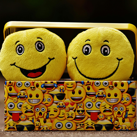 An image featuring a collection of happy emojis in vibrant yellow, illustrating the cheerful and optimistic aspects of yellow color psychology.