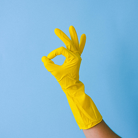 An image of a hand adorned with bright yellow gloves, forming the "nice" sign, showcasing the positive and uplifting impact of yellow color psychology.